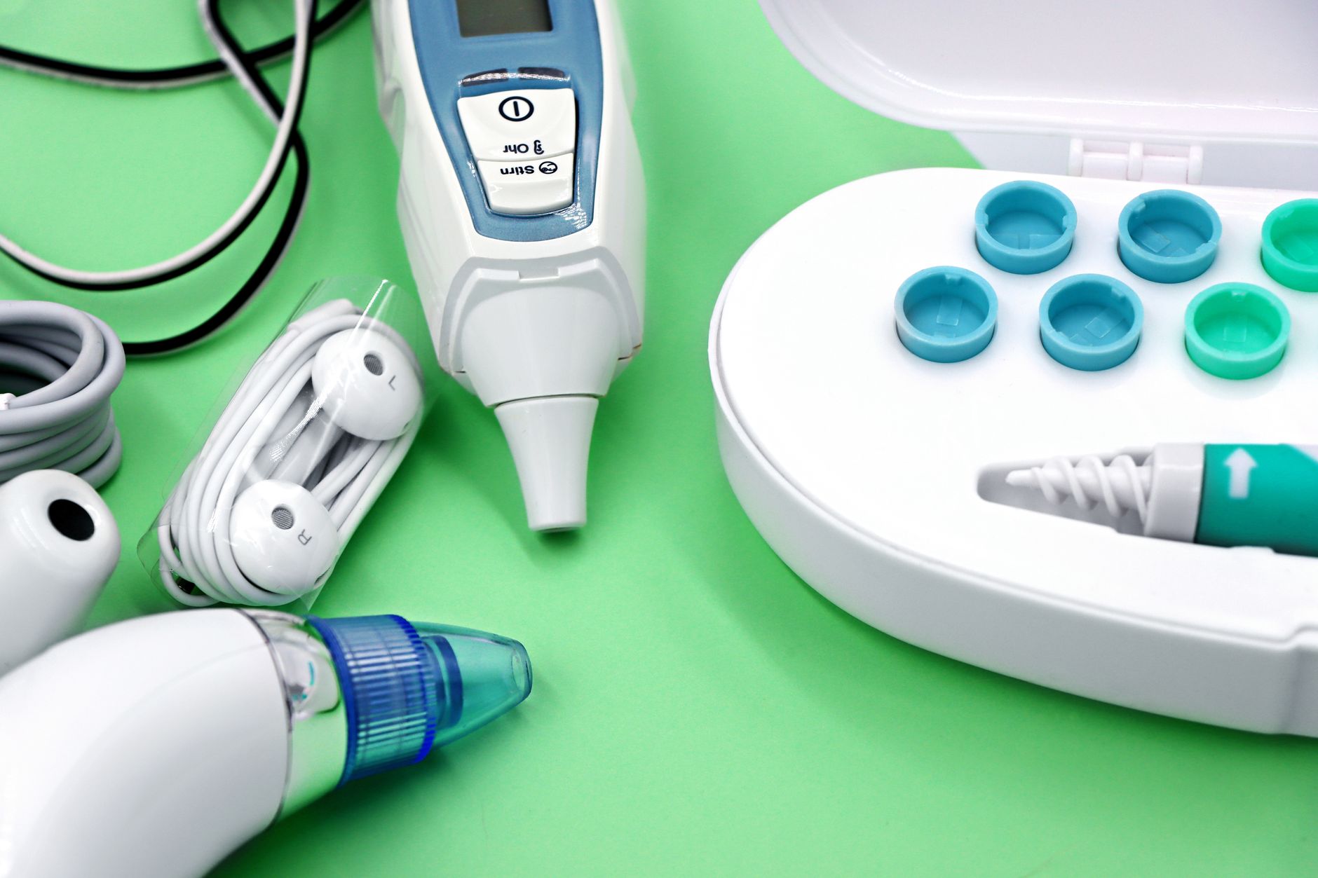 Ear wax removal tools and accessories on a green background